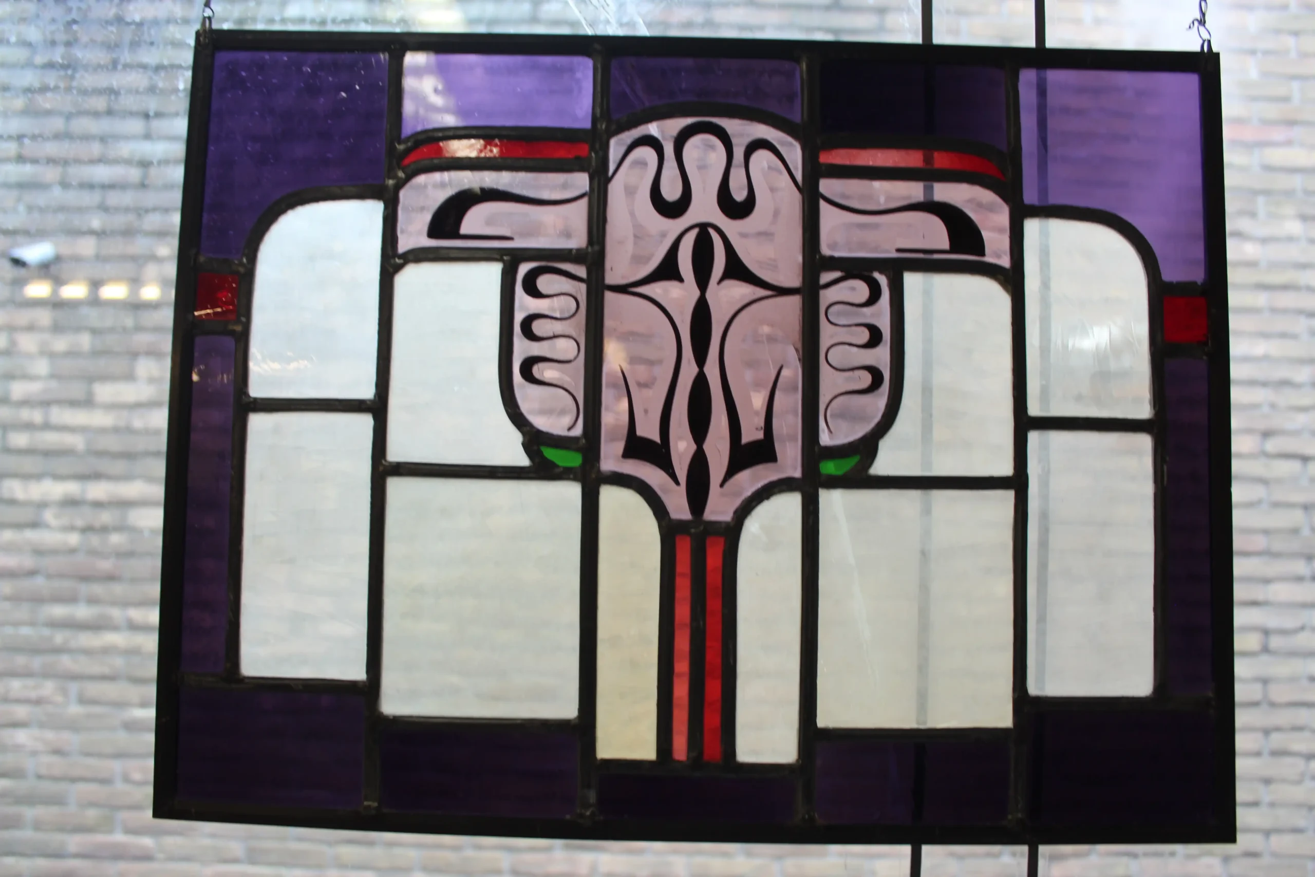 Twee Amsterdamse school glas in lood ramen